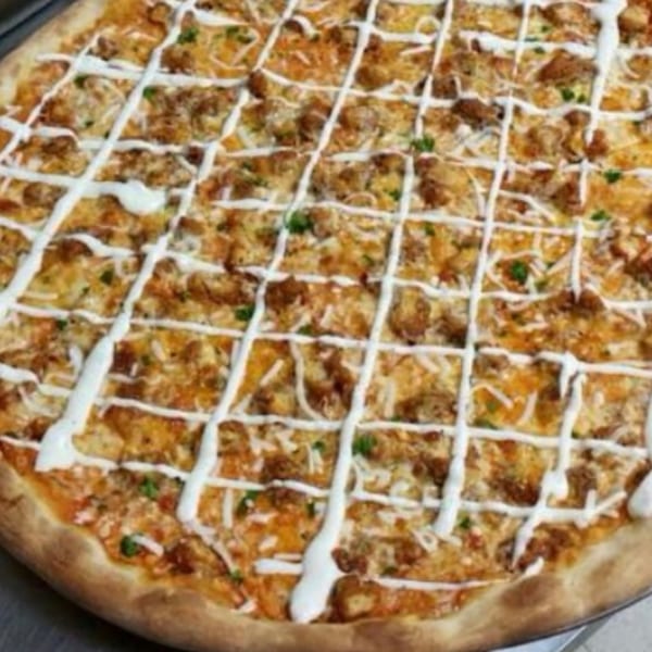 A whole Pizzany's Pizzeria pizza with melted cheese, meat, and a white sauce drizzle.