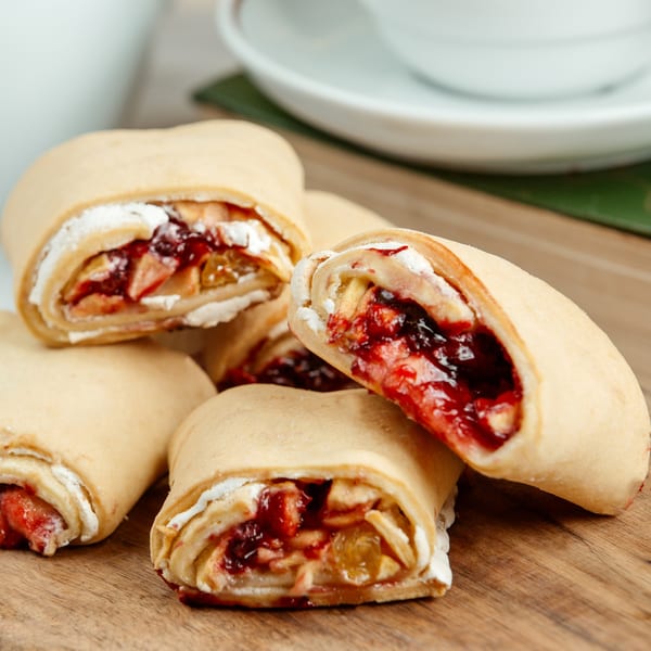 Sweet dessert rolls filled with fruit and cream, on a wooden board at Pizzany's Pizzeria.